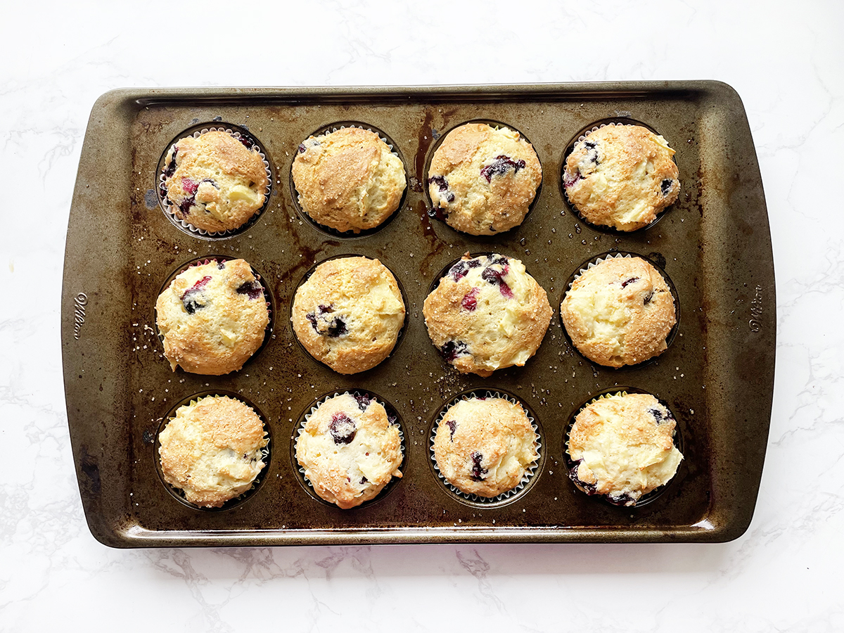 Baked apple blueberry muffins in a tin.