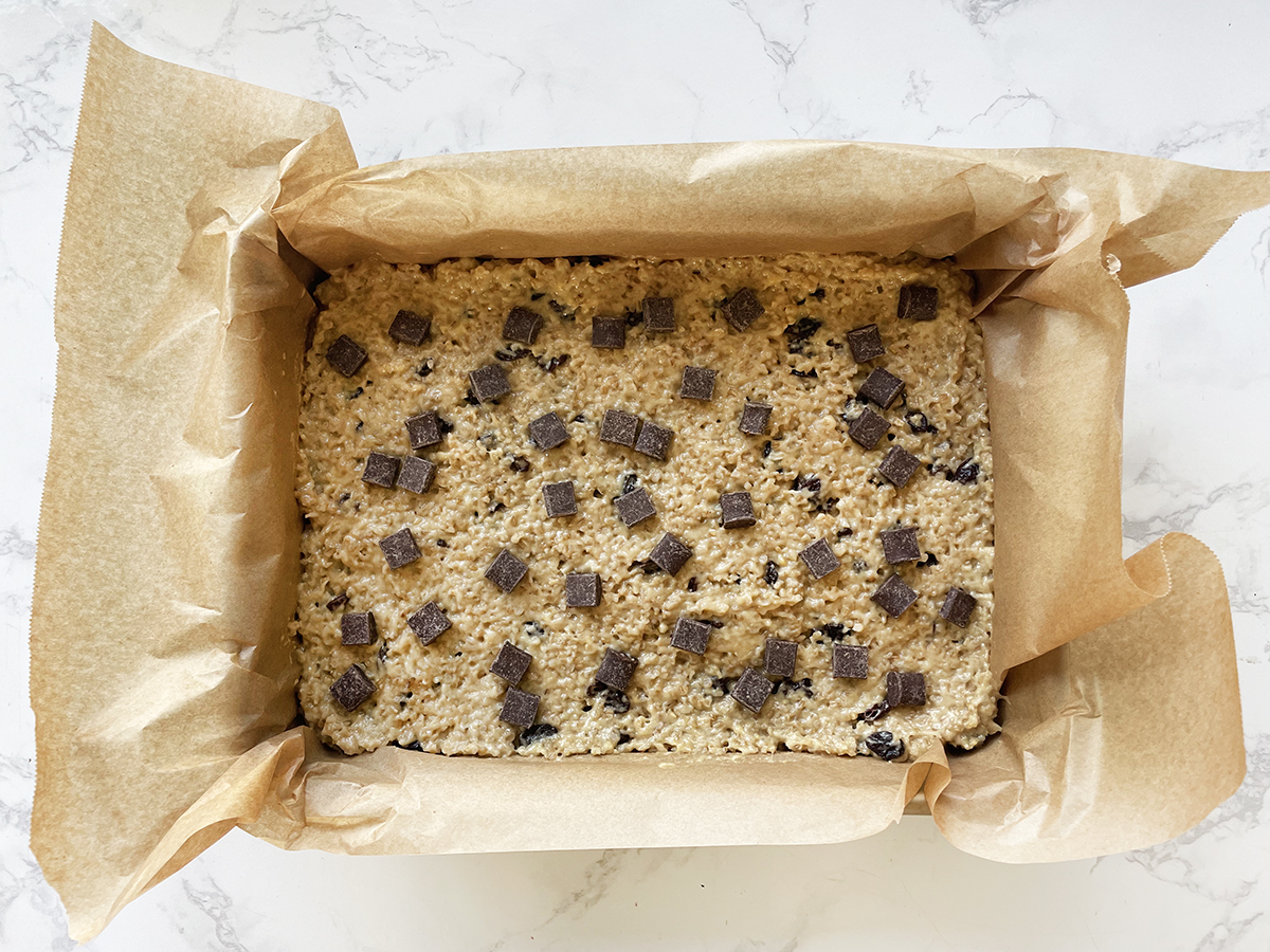 Steel cut oatmeal bars topped with chocolate chunks ready to bake.
