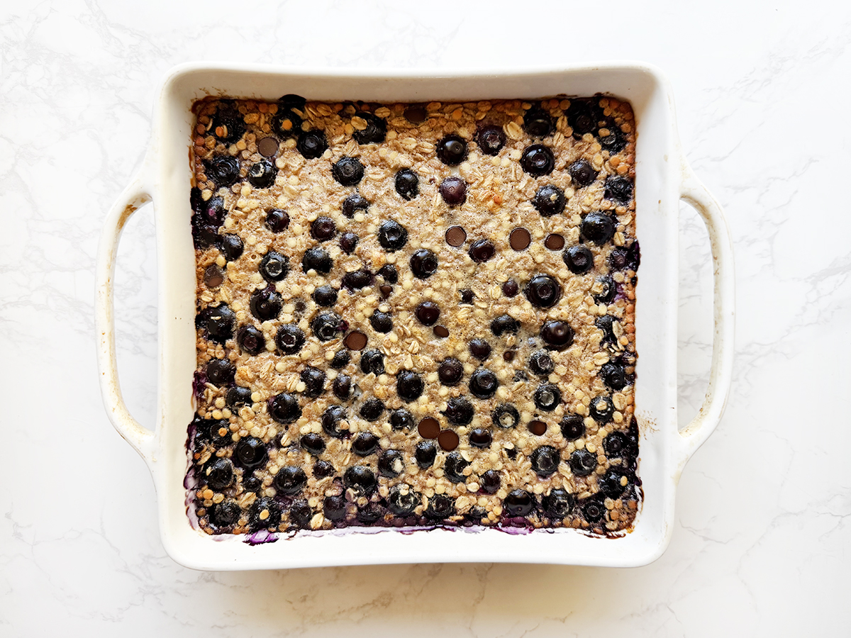 Baked pan of oatmeal with blueberries and chocolate chips on top.