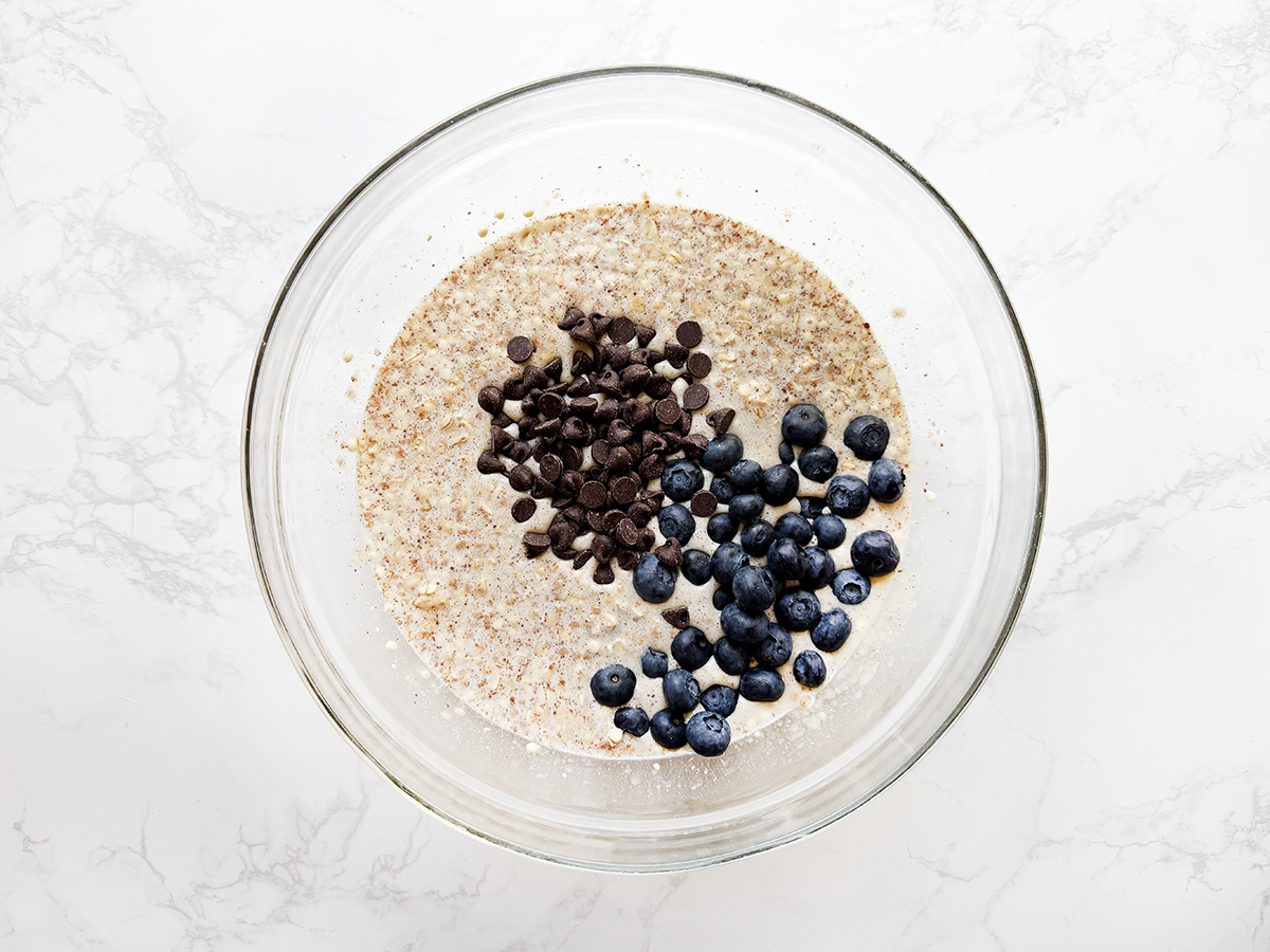 Bowl with oatmeal, milk, berries and chocolate chips.