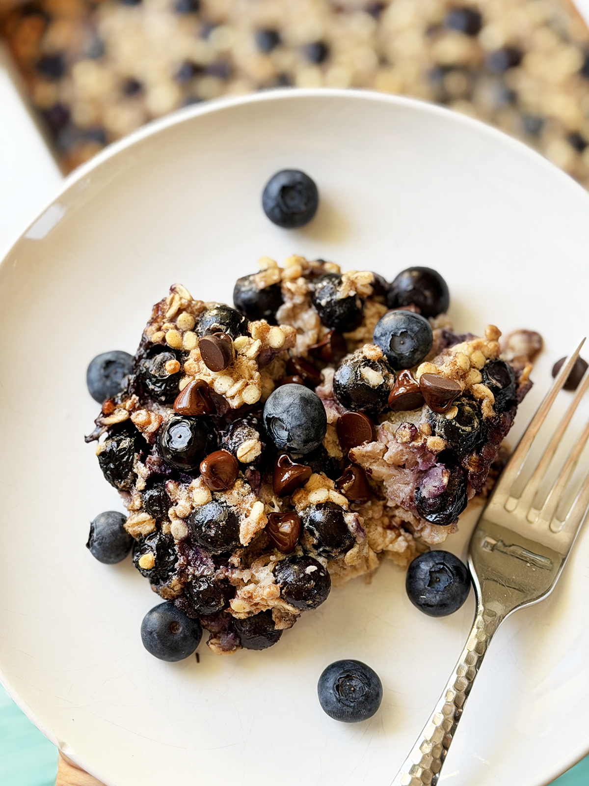 Plate of oatmeal with blueberries and chocolate chips.