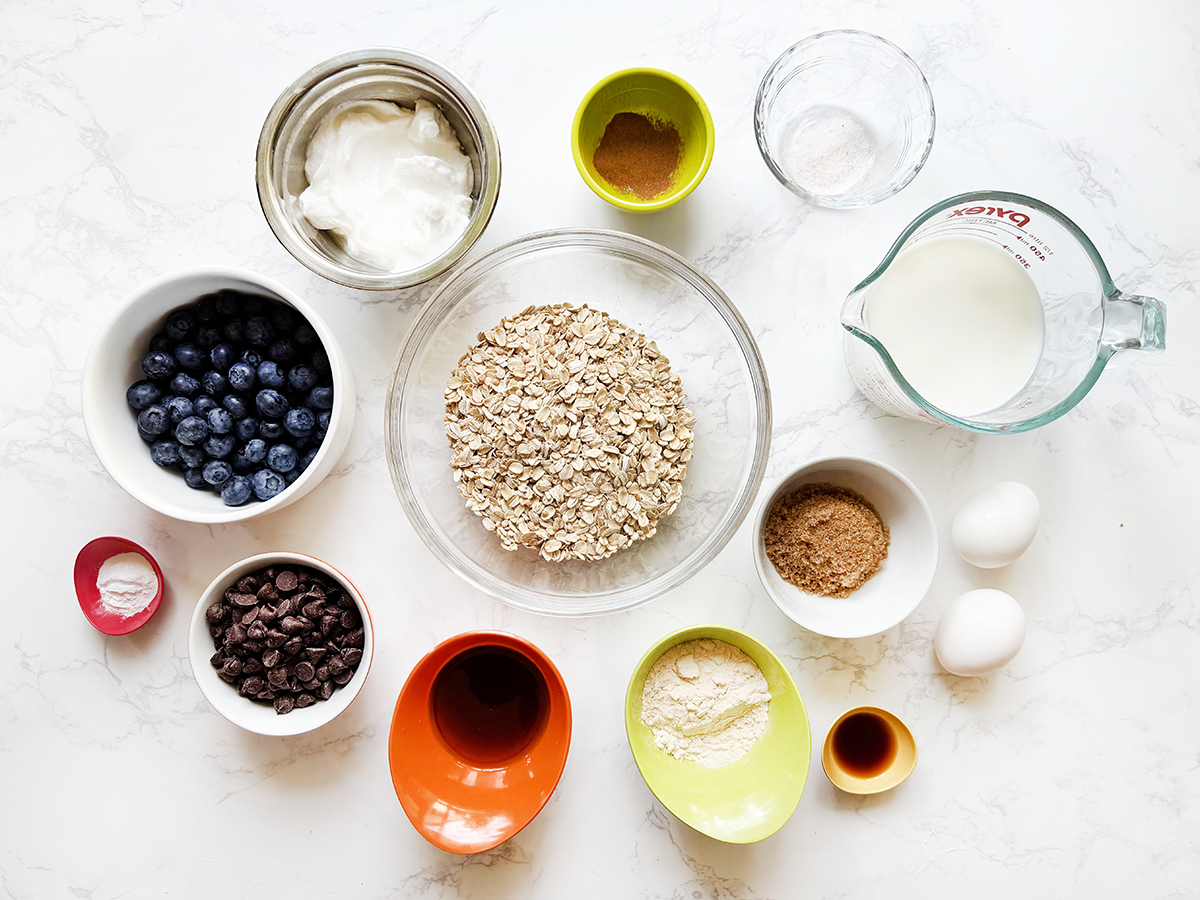Ingredients on a white surface for baked oatmeal.