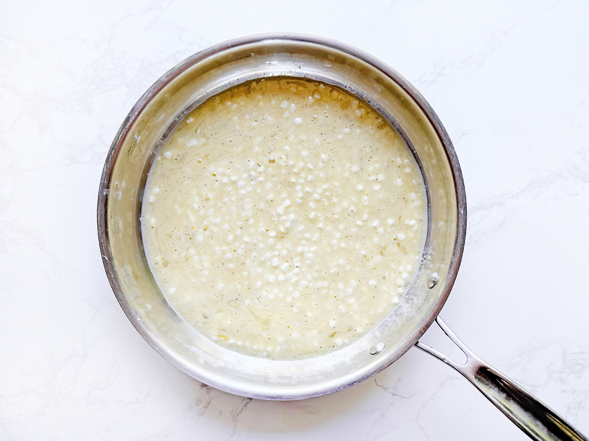 Beaten eggs with cottage cheese in a skillet.