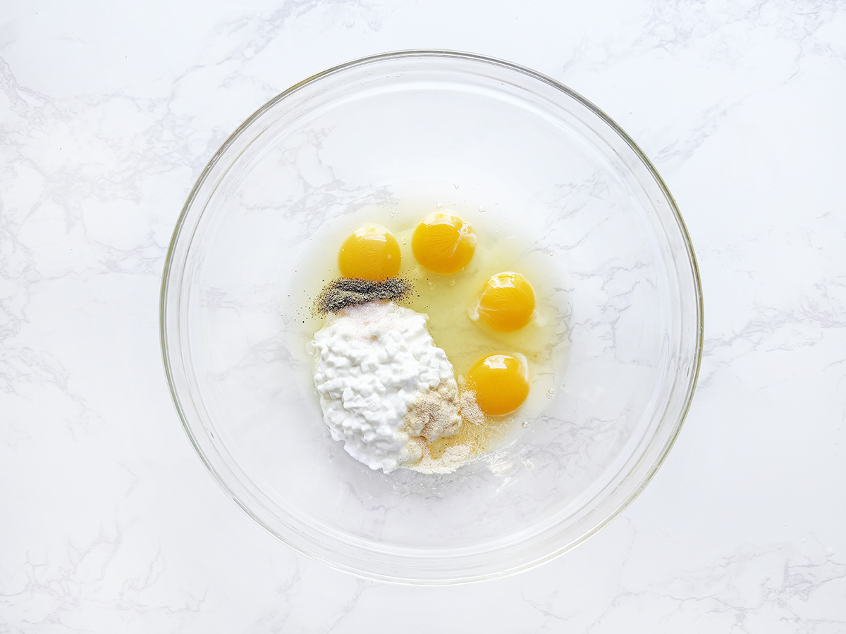 Eggs and cottage cheese in a glass mixing bowl.