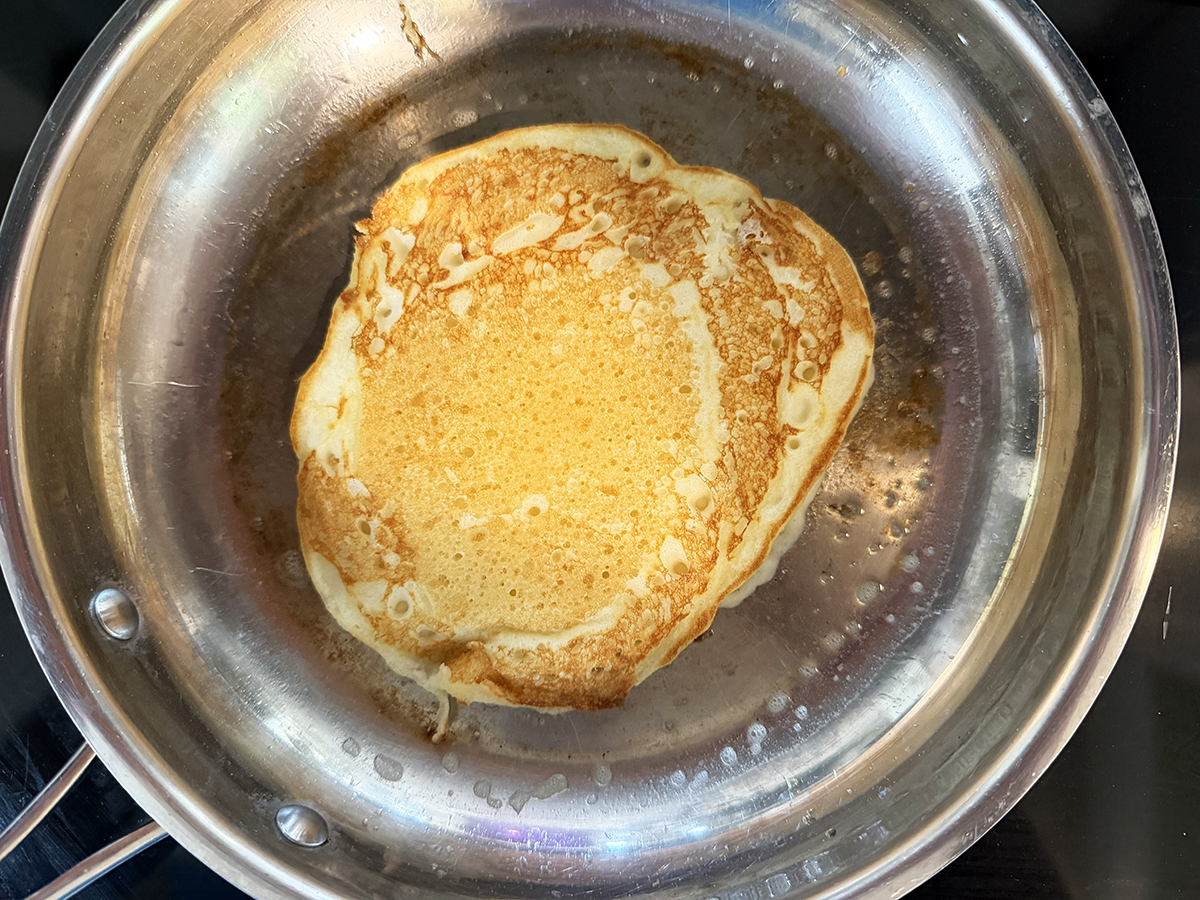 Finished golden pancake in hot skillet.