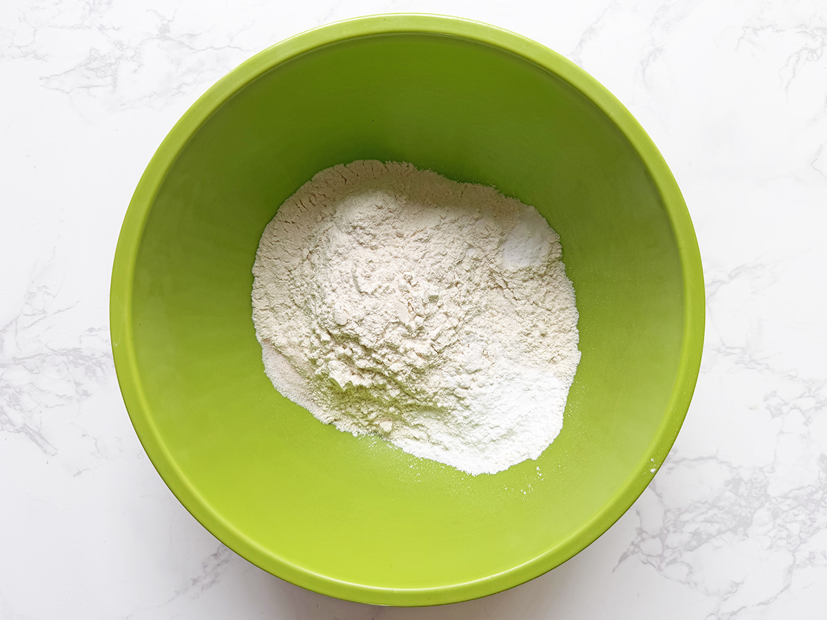 Dry ingredients for pancakes in a green bowl.