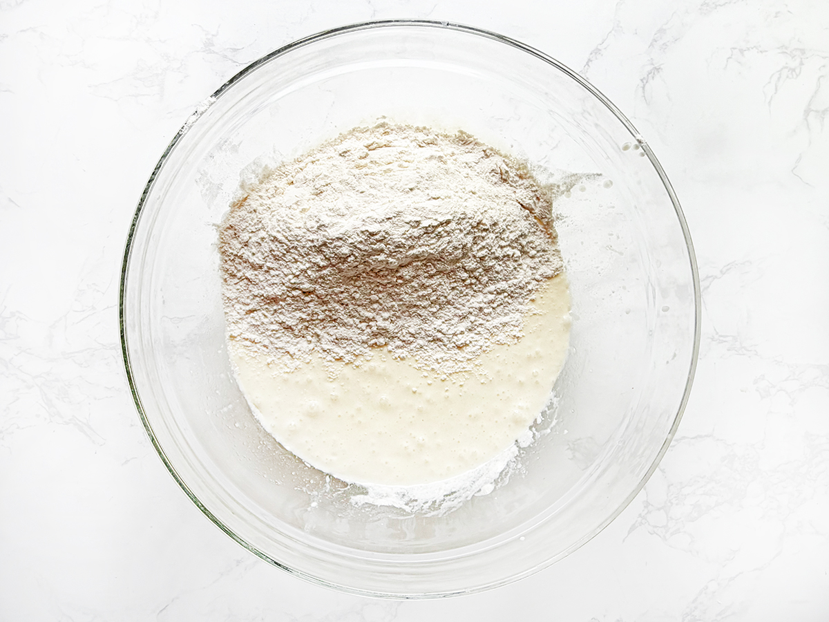 Dry ingredients being mixed with wet ingredients to make pancake batter.