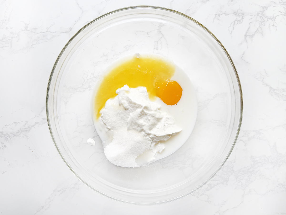 Wet ingredients for pancakes in a glass bowl.