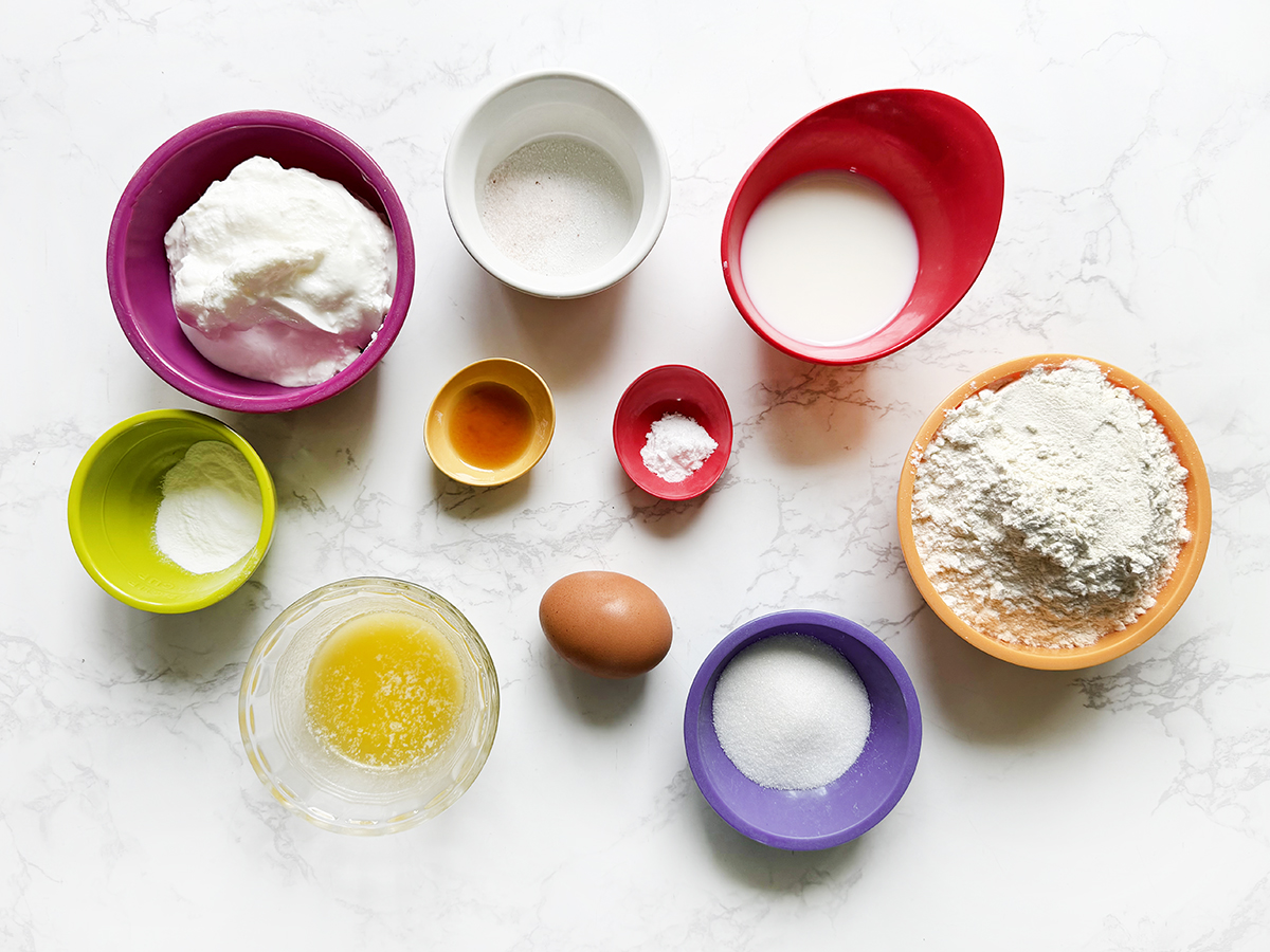 Ingredients for Greek yogurt pancakes lined up on a white counter.